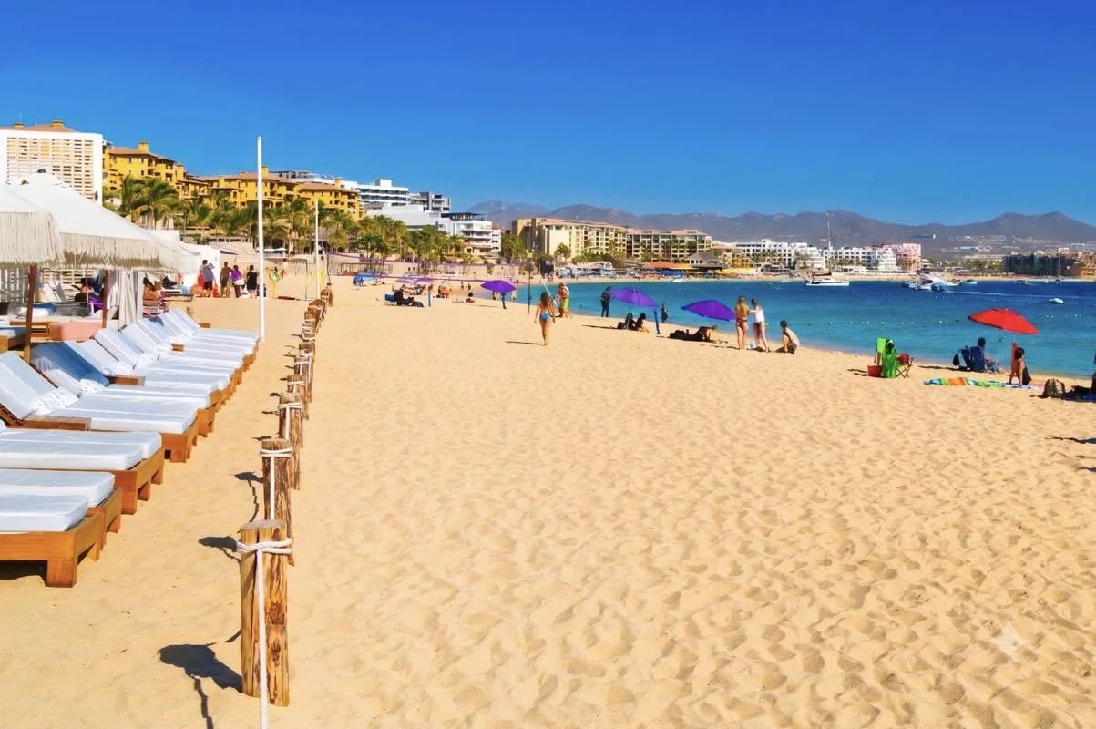 Daybeds and white umbrellas along Medano Beach in Cabo San Lucas